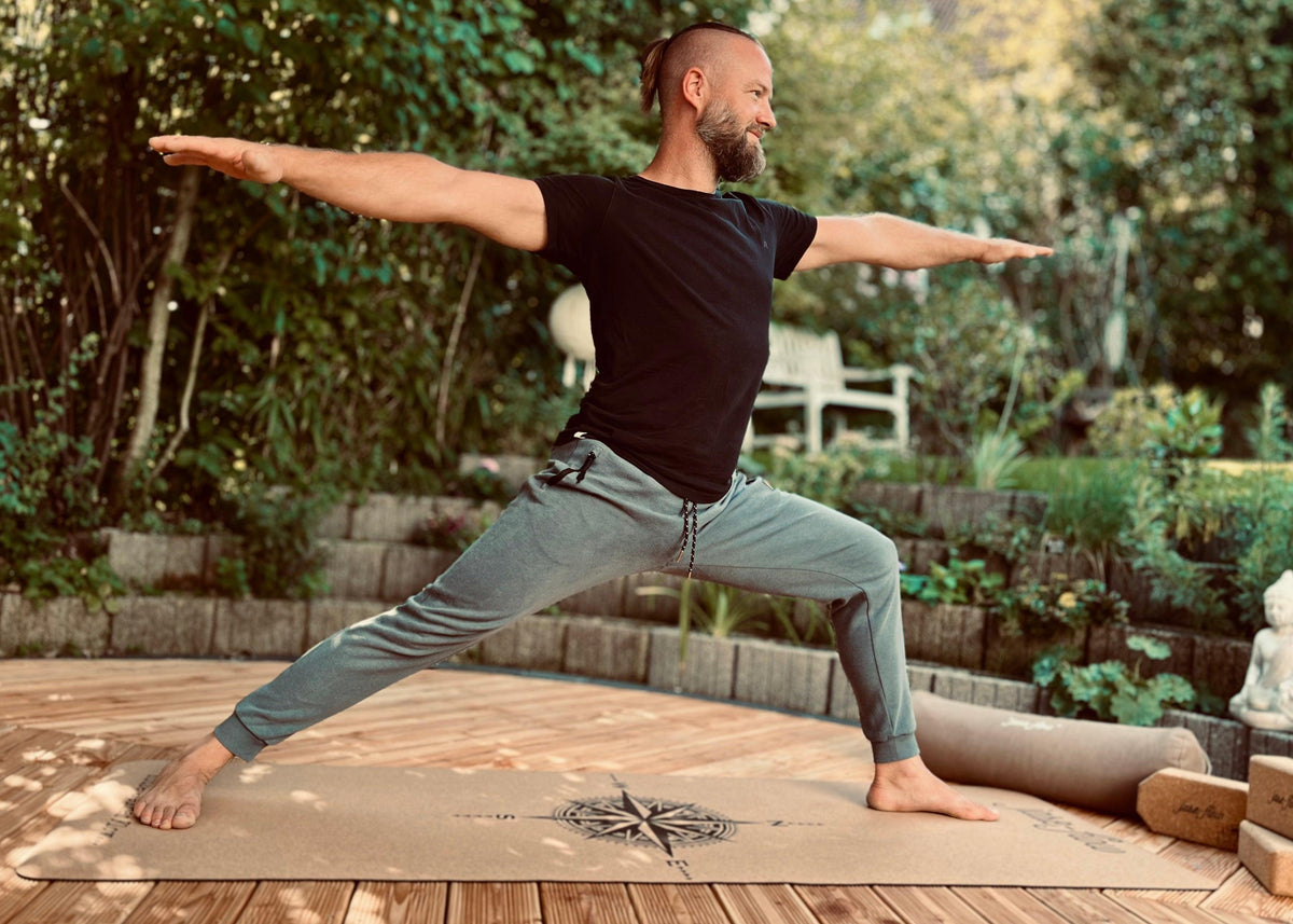 Stefan Gründer und CEO mit der Asana Krieger auf der Yogamatte Kork Kompass - Yogabolster und Yogablöcke sind beim Training mit dabei für optimale Unterstützung