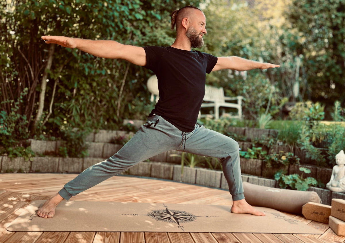Stefan Gründer und  CEO mit der Asana Krieger auf der Yogamatte Kork Kompass -  Yogabolster und Yogablöcke sind beim Training mit dabei für optimale Unterstützung