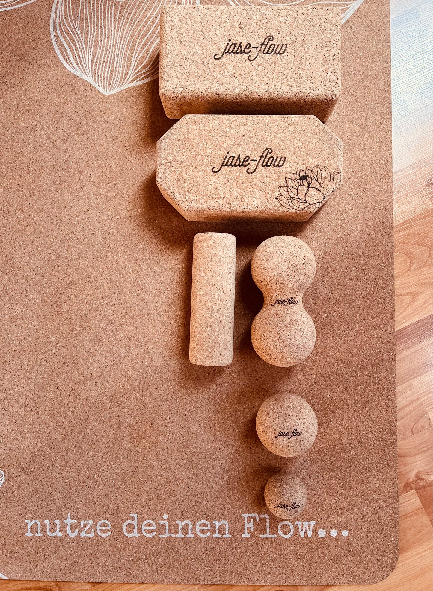 jase-flow´s Yogazubehör umweltfreundlich und nachhaltig mit Yogablock  und Faszien-Zubehör auf der Yogamatte Kork Lotus drapiert 