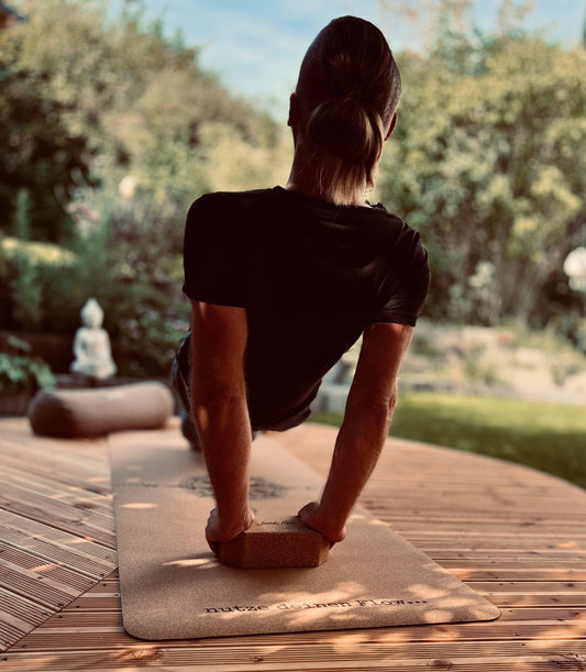 Stefan Gründer und CEO mit einem Reserve Plank  auf der Yogamatte  Kork Kompass mit Unterstützung von einem Yogablock 